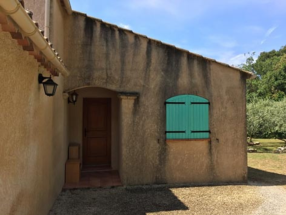 Façade de maison provençale nettoyée, volets verts